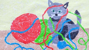 Praca plastyczna przedstawiająca kota zaplątanego w kolorowe nici wyciągnięte z kulek wełny.