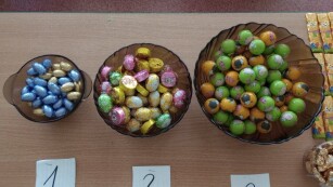 Zdjęcie 3 przedstawia jajka czekoladowe o różnych kolorach opakowań w 3 oddzielnych miskach
